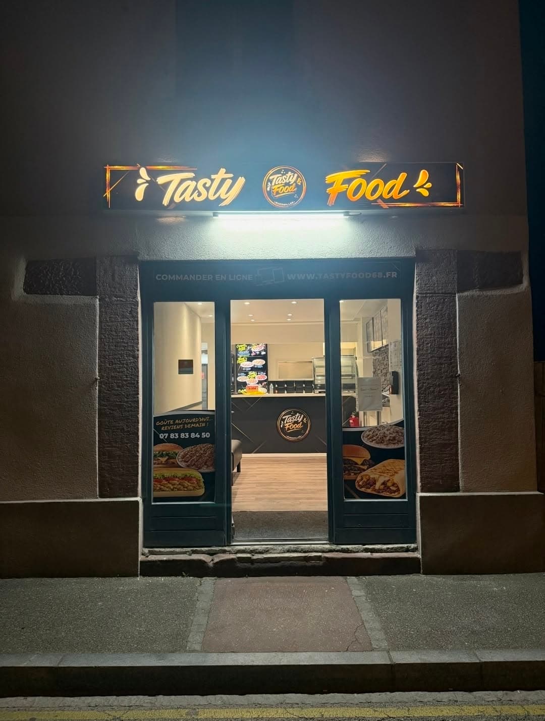 Devanture du snack Le So'Chaud à Guebwiller, illuminée la nuit